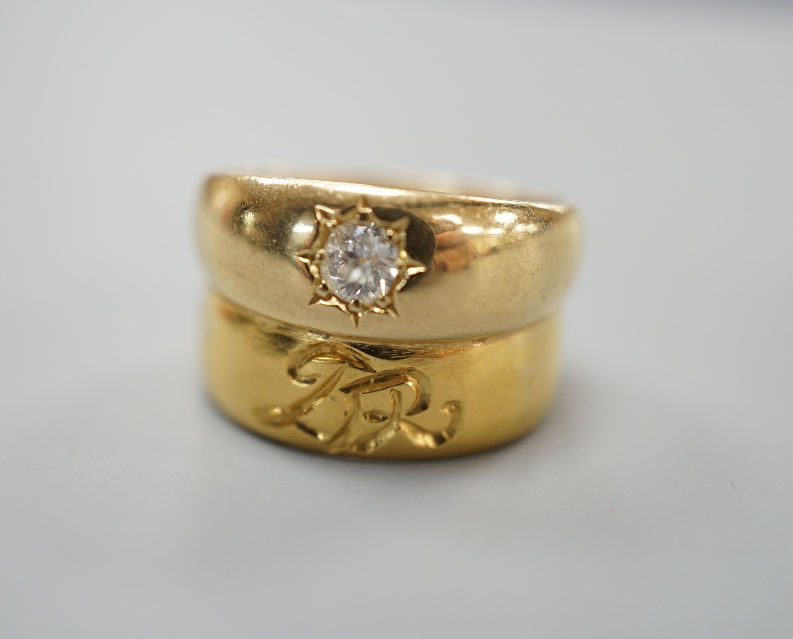 A 22ct gold band, welded to an 18ct gold and diamond set band, size L, gross weight 8.3 grams.